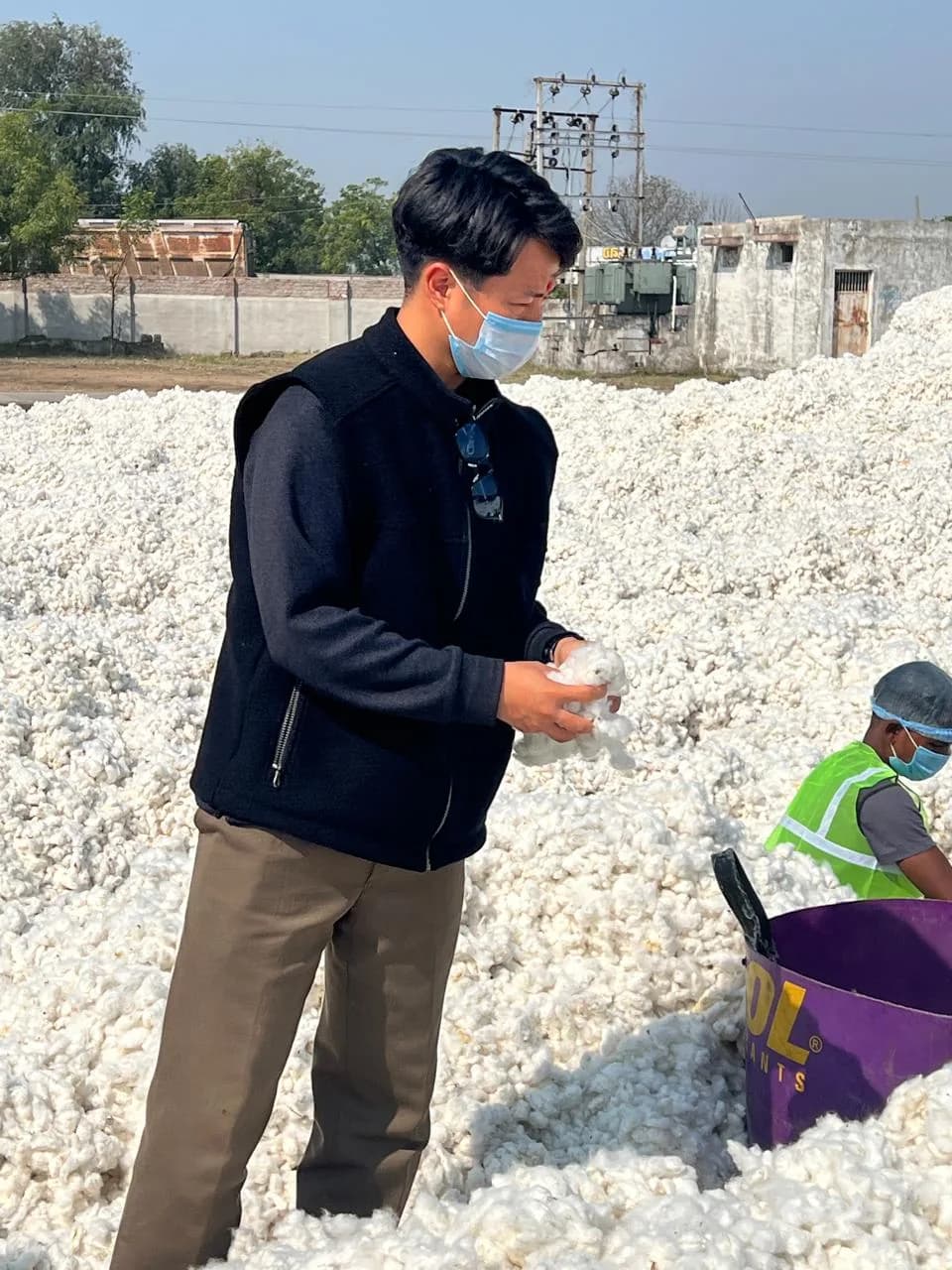 Client checking the quality of raw cotton by hand
