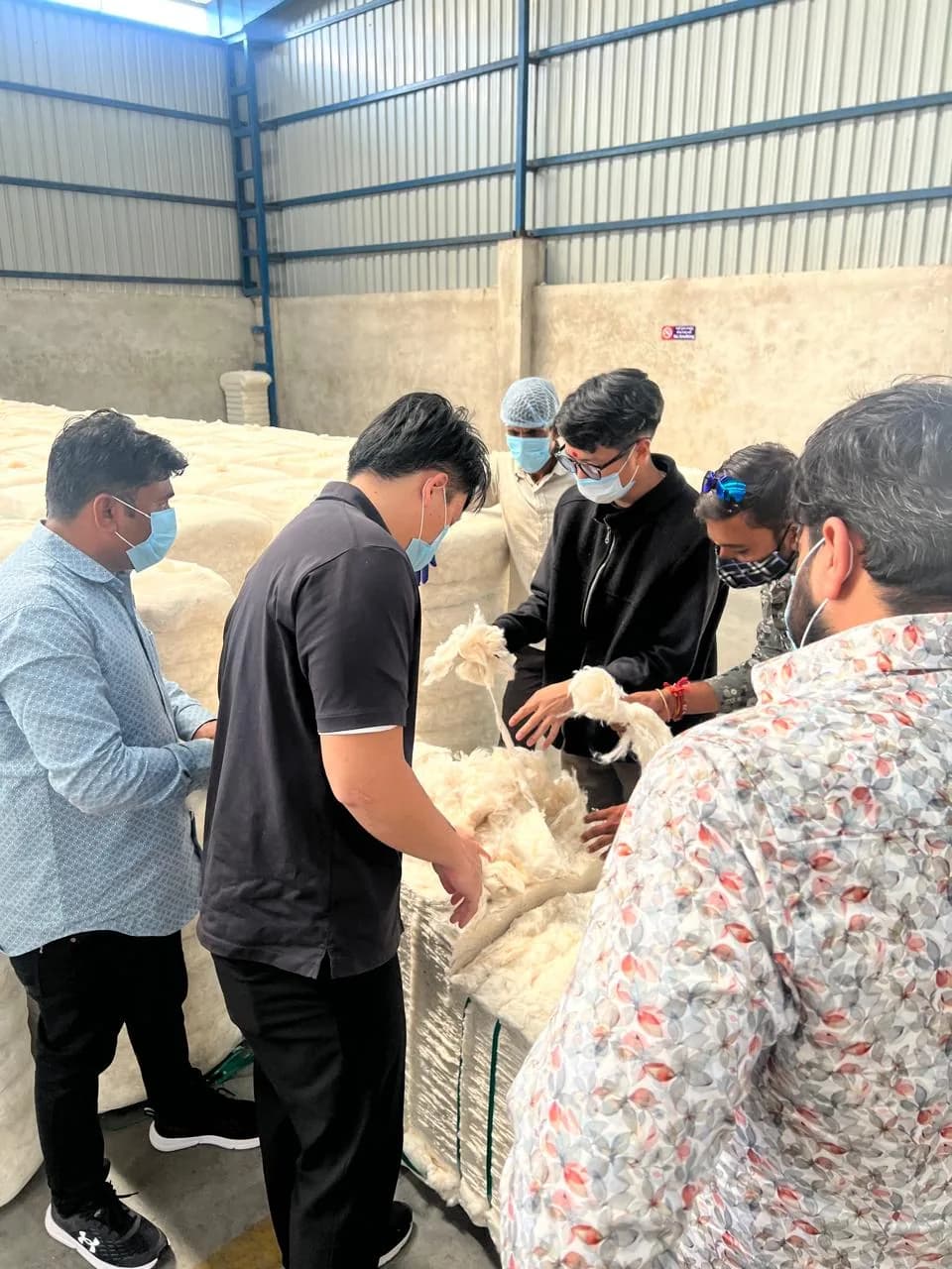 Clients examining cotton fibre from a bale in the warehouse