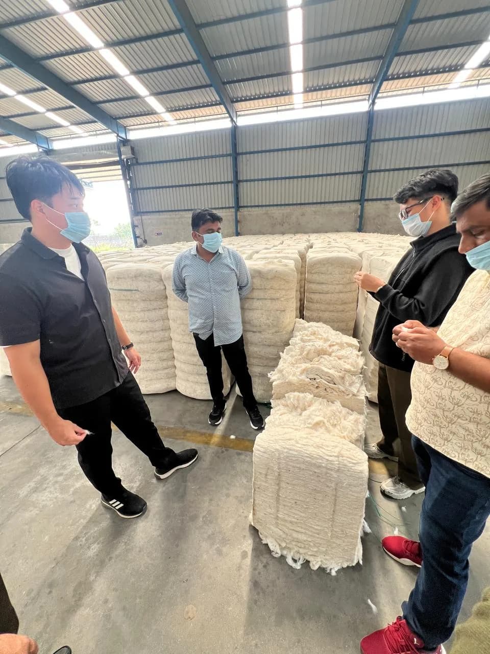 Clients reviewing pressed cotton bales in the warehouse