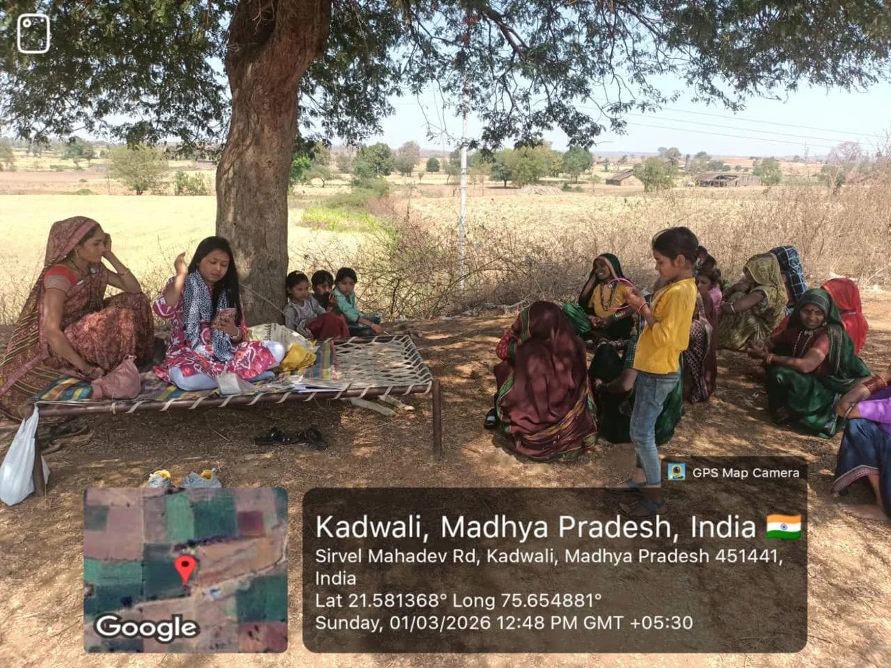 Women and children at an outdoor community meeting