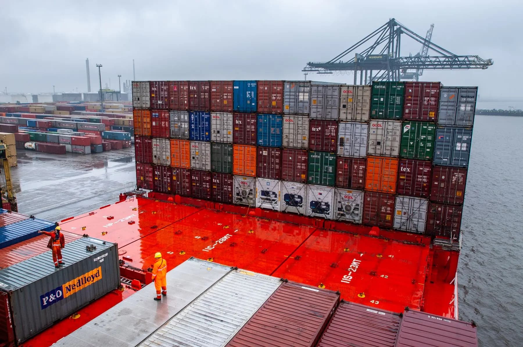 Dock workers preparing stacked containers for loading