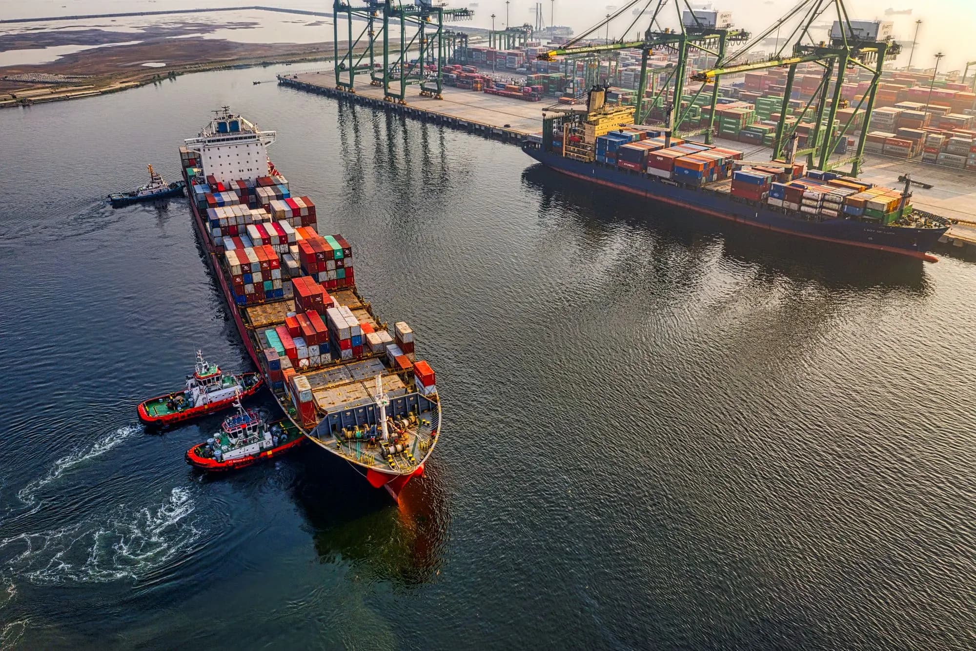 Aerial view of container ships and cranes at a commercial port