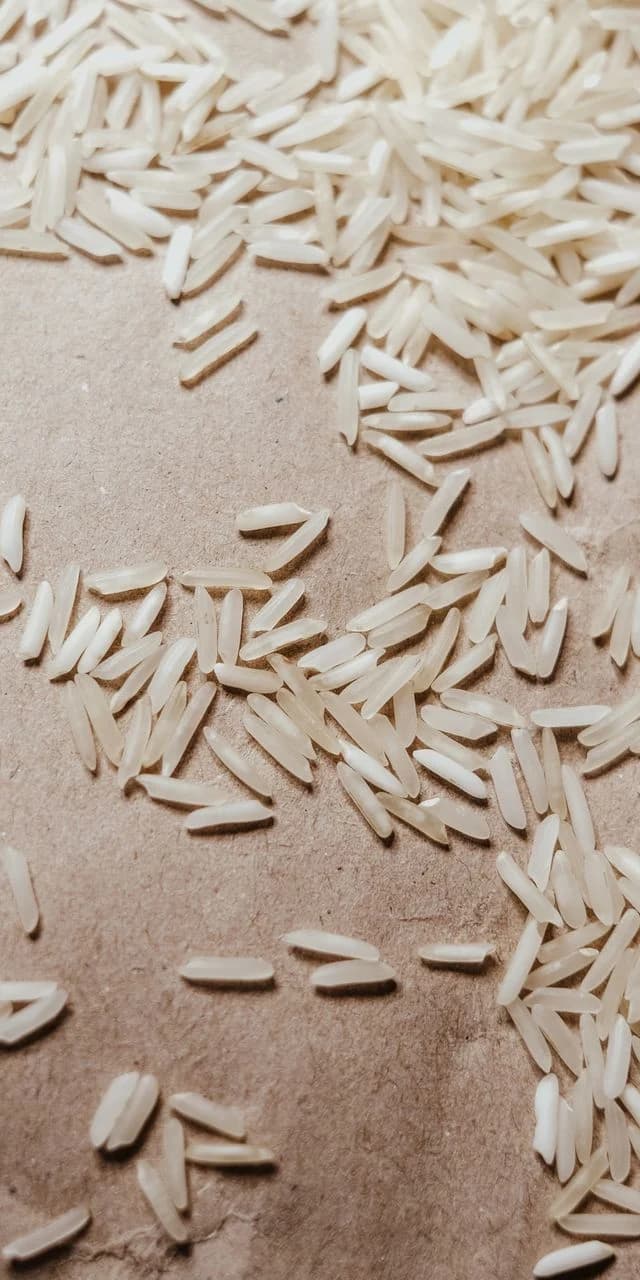 Long-grain white rice scattered on brown paper